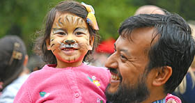 Little girl being carried by her father at a festival 