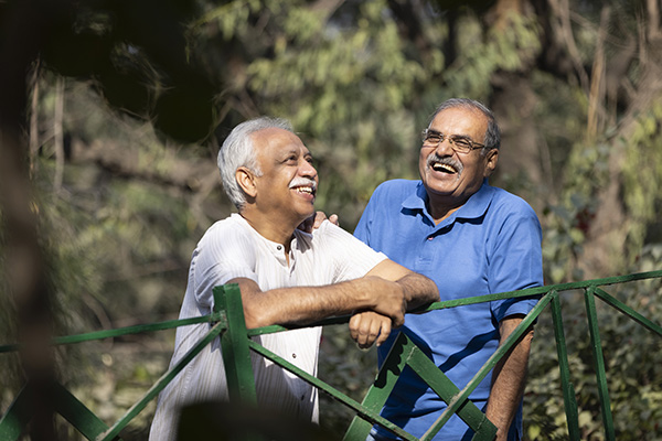 Two men laughing and walking in the park