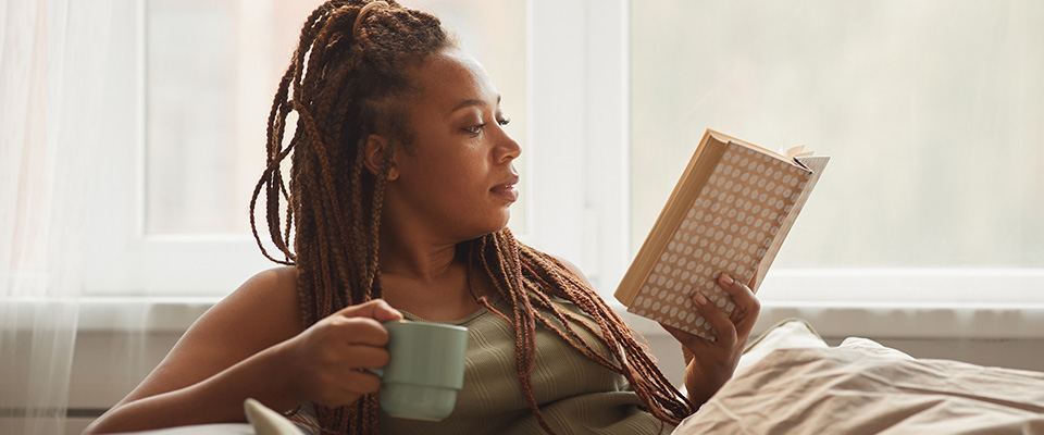 Lady reading book on sofa