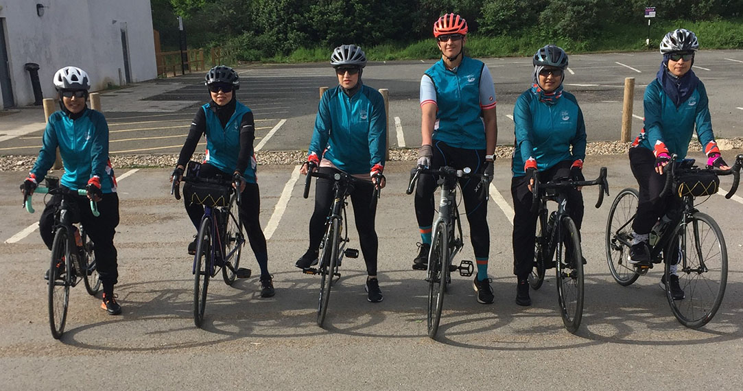 Group of six female cyclists sitting on bikes