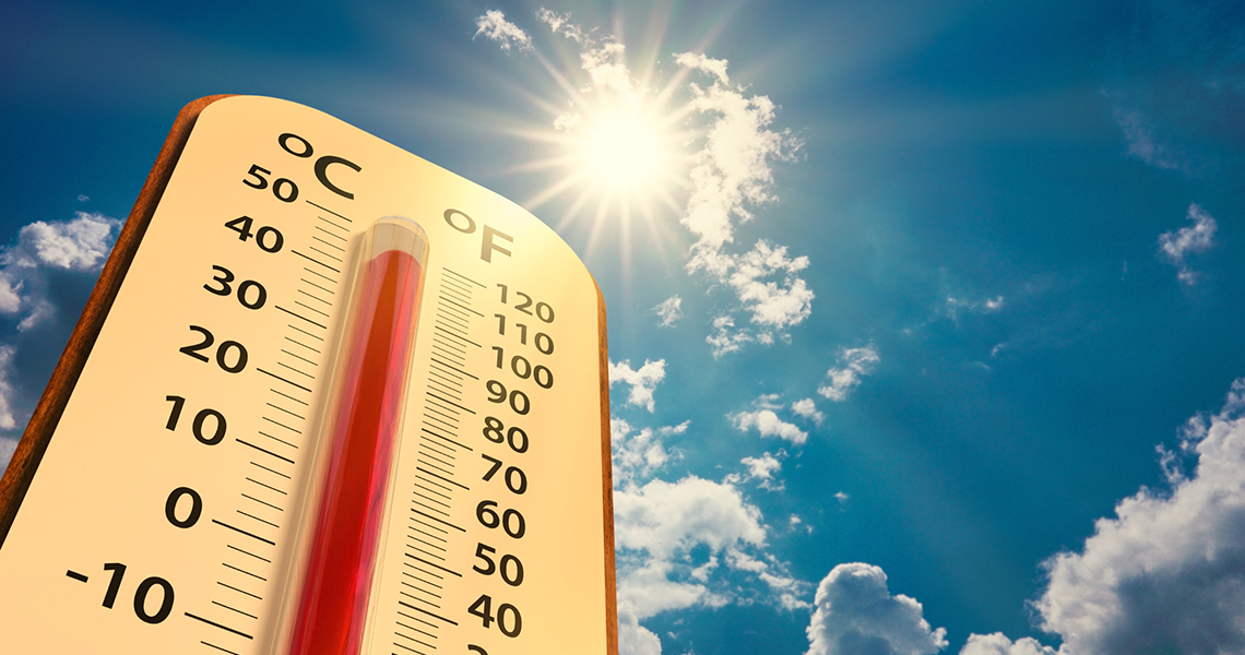 Thermometer on blue sky with sun shining