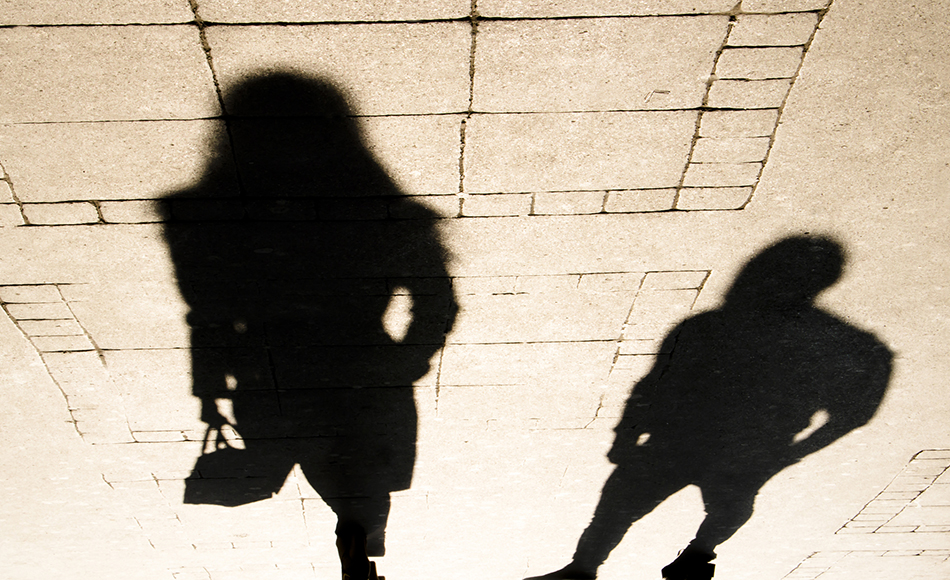 Silhouette shadow of a woman and a man on city sidewalk