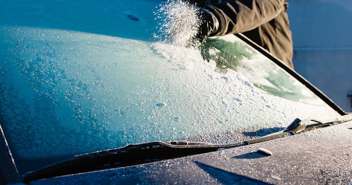 A person scraping a windscreen