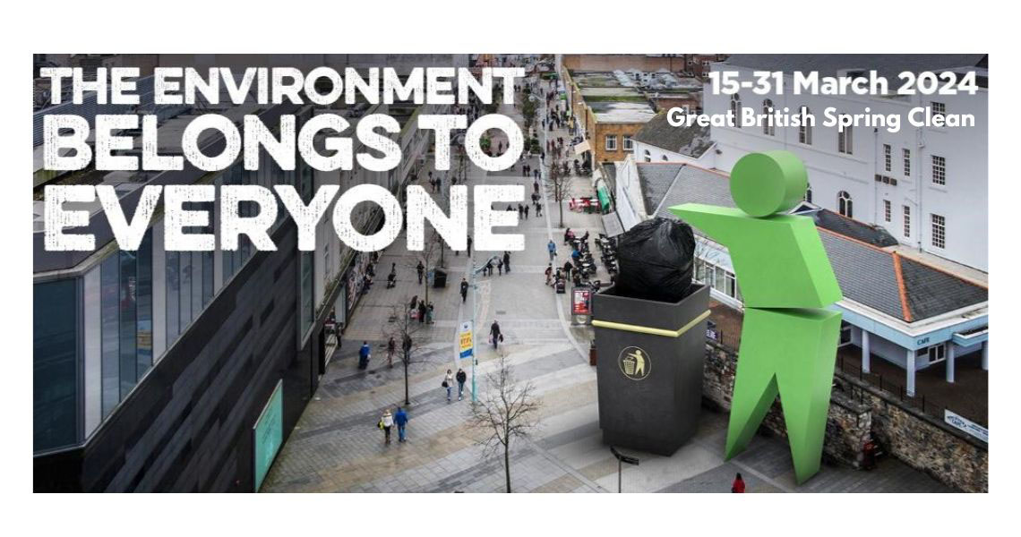 large bin and green person putting litter in giant bin