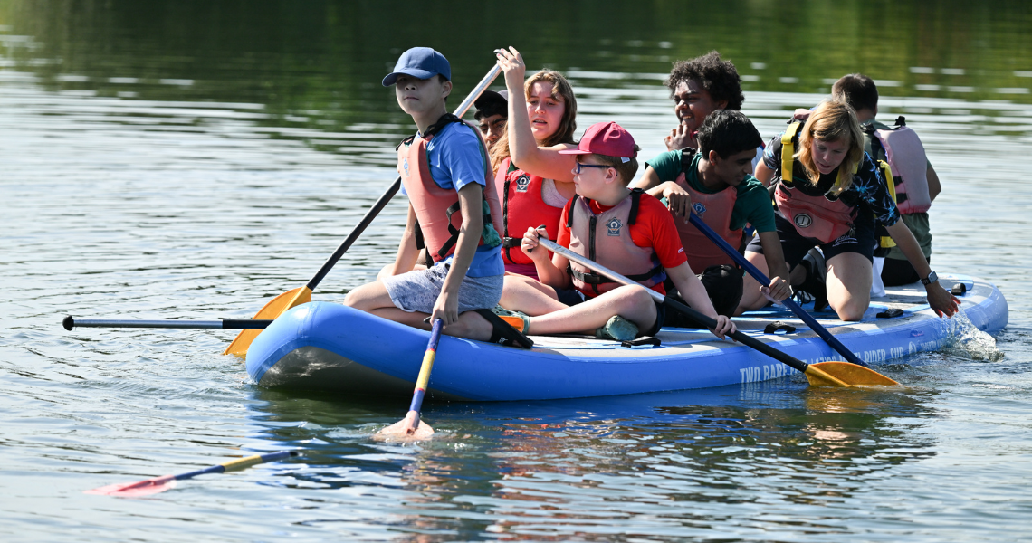 Young people steering boat