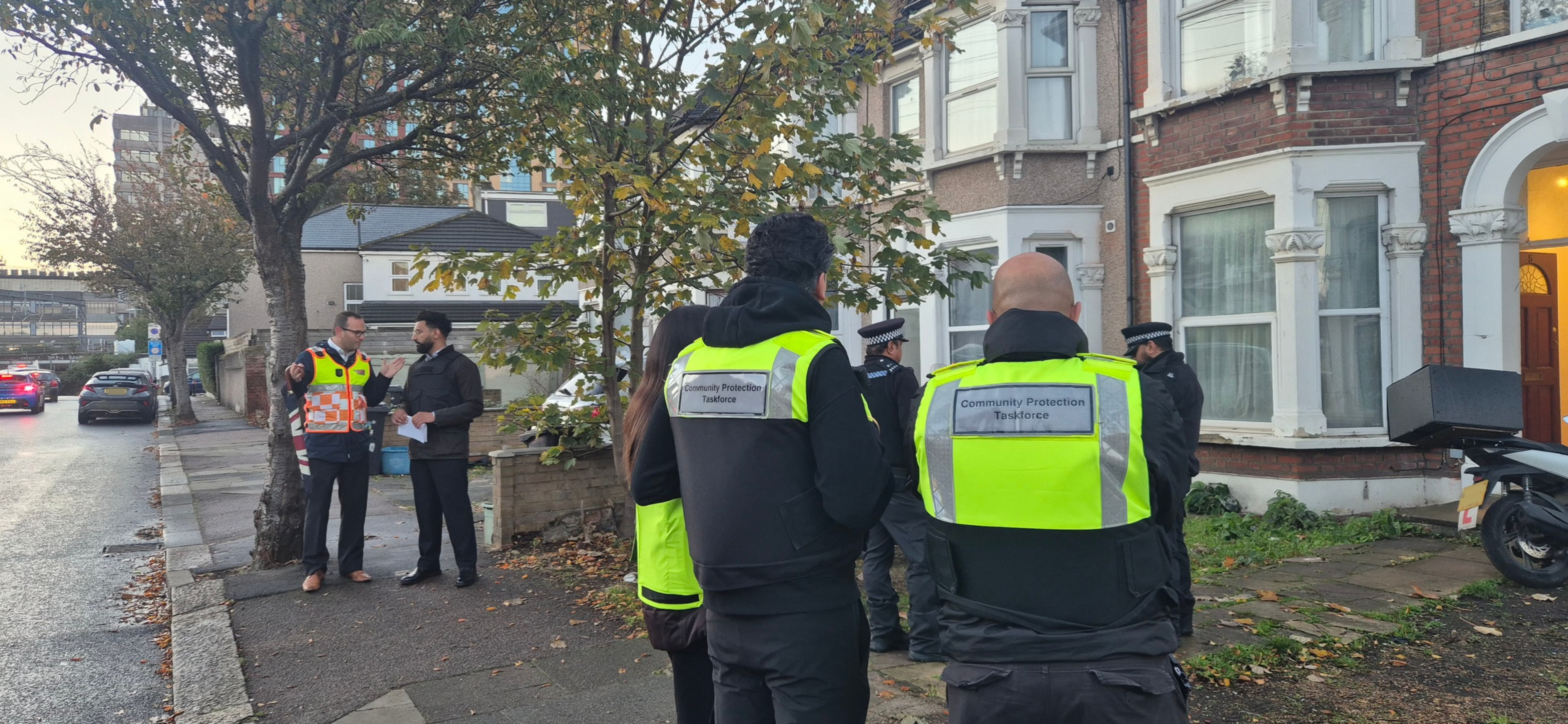 Councillor Sunny Brar, Cabinet Member for Enforcement, Community Safety and Cohesion speaks with Director of Community Safety whilst the Community Protection Taskforce and Met Police action warrants on properties