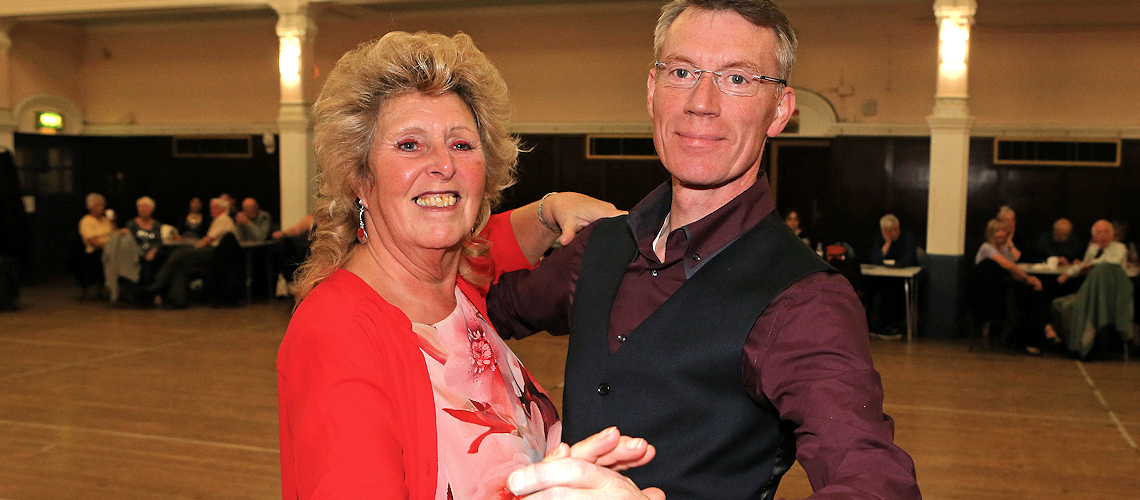 a couple dancing and smiling at the camera