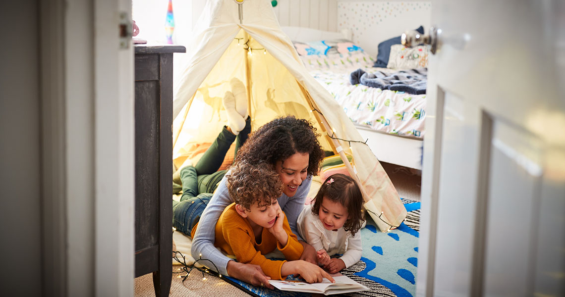 image of woman reading with two children