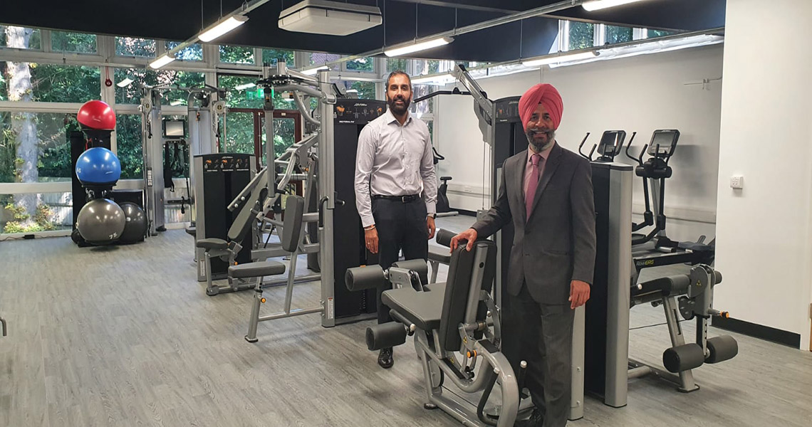 Leader and Deputy Leader of Redbridge Council standing by gym equipment