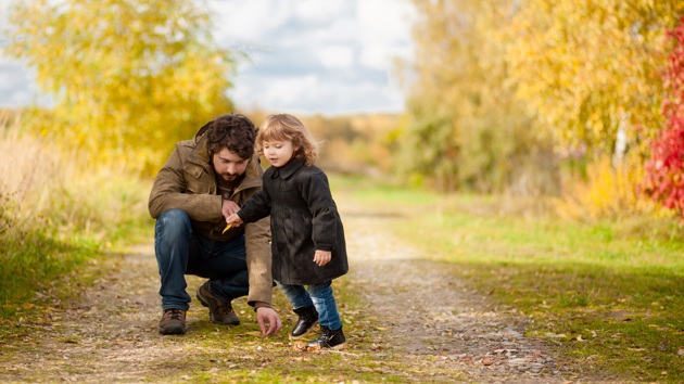 A father and daughter in a park in autumn 