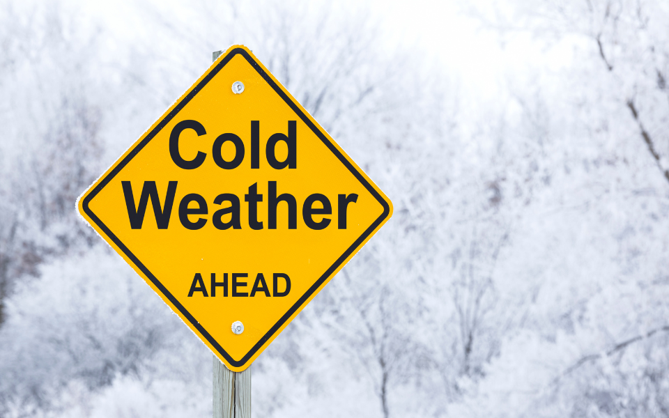Frosty day with warning sign that reads 'cold weather ahead'