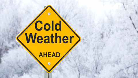 Frosty day with warning sign that reads 'cold weather ahead'