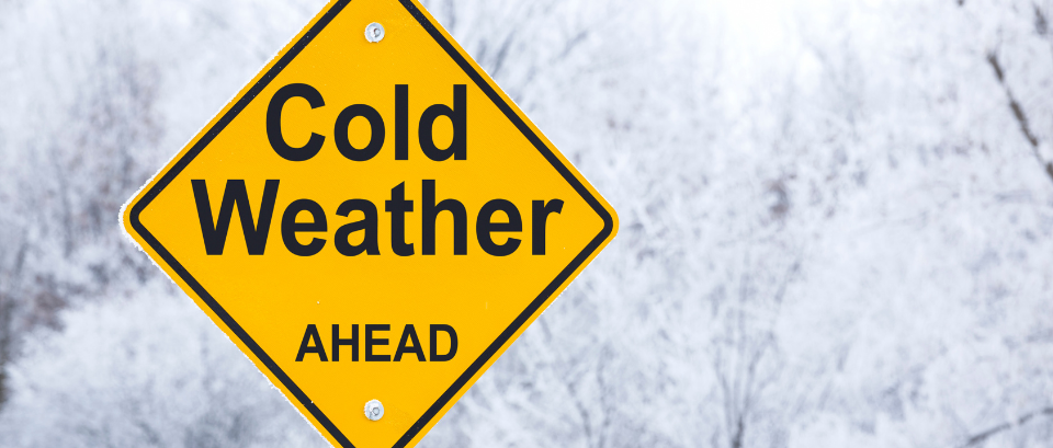 Frosty day with warning sign that reads 'cold weather ahead'