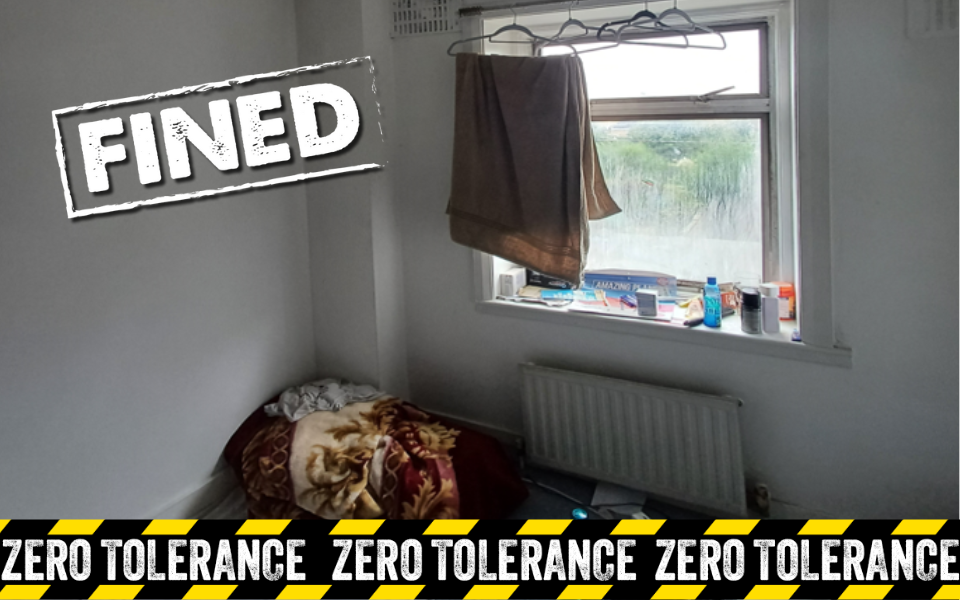 Room with bedding on floor with zero tolerance design and 'Fined' stamp
