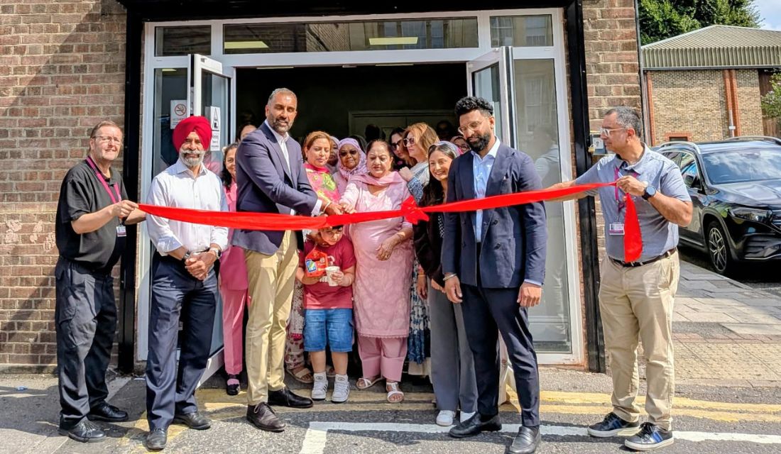 Councillors and community groups cutting a red ribbon to open Janice Mews