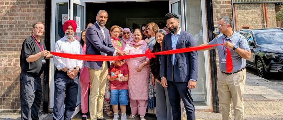 Councillors and community groups cutting a red ribbon to open Janice Mews