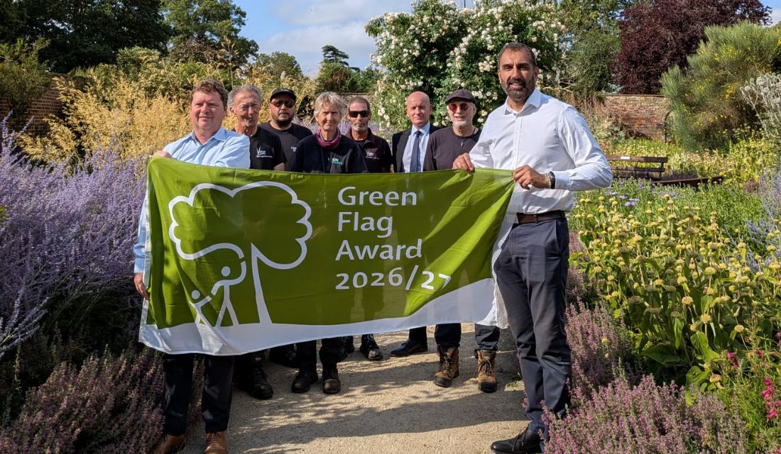 Leader of the council and parks colleagues with a green flag award flag in Valentines Park