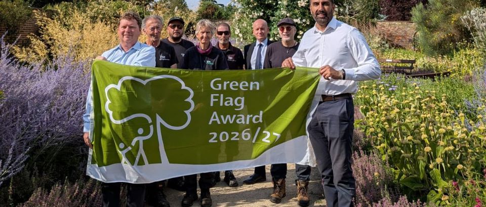Leader of the council and parks colleagues with a green flag award flag in Valentines Park