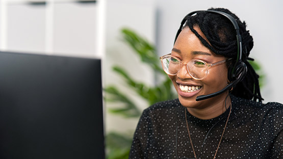 Lady wearing telephone handset looking at monitor image