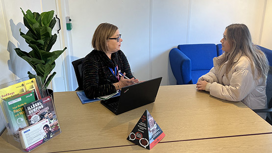 Member of the customer service team talking to a resident in the office image