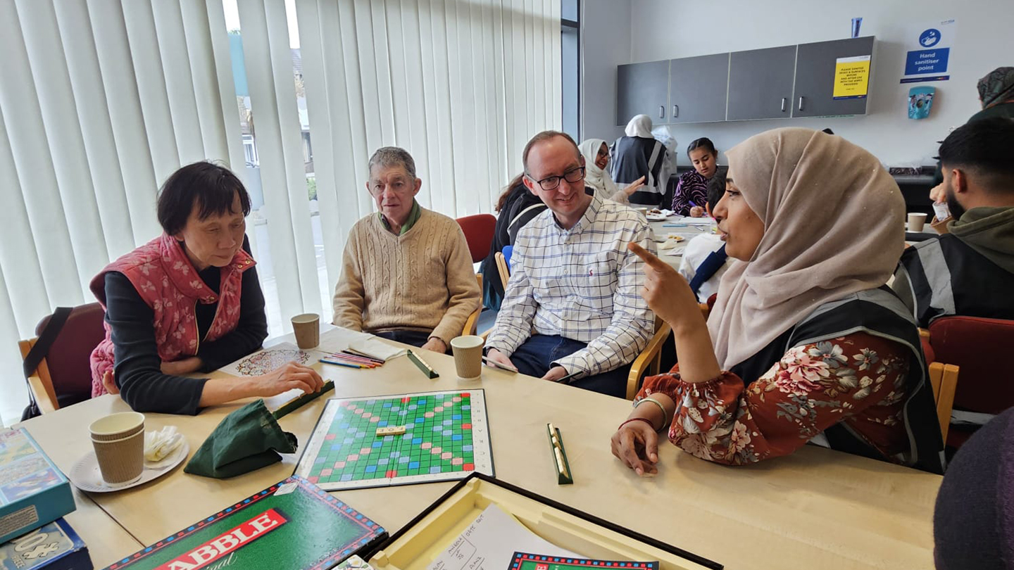 Residents at a community cafe playing scrabble game image